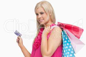 Smiling blonde holding shopping bags and credit card