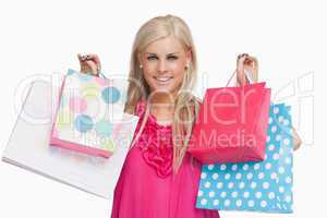 Smiling blonde showing shopping bags