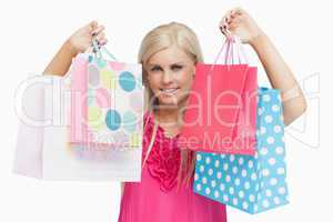 Happy blonde showing shopping bags