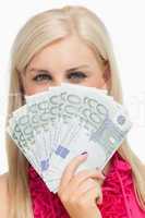 Beautiful blonde holding 100 euros banknotes