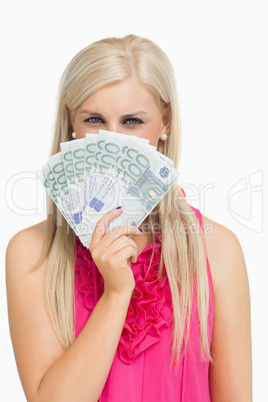 Blonde in pink holding 100 euros banknotes