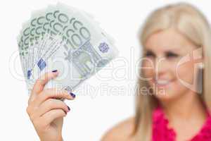 Blonde showing 100 euros banknotes