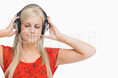 Blonde in orange dress listening to music