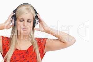Blonde in orange dress listening to music