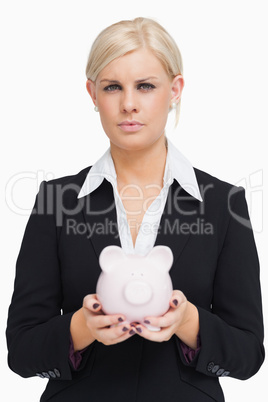 Serious businesswoman holding a piggy-bank Serious businesswoman holding a piggy-bank