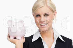 Smiling businesswoman holding a piggy-bank