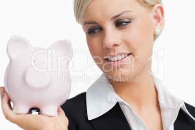 Cute businesswoman holding a piggy-bank