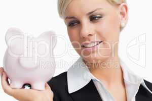 Cute businesswoman holding a piggy-bank