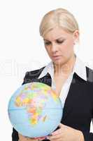 Stern businesswoman holding a globe
