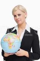 Serious businesswoman holding a globe