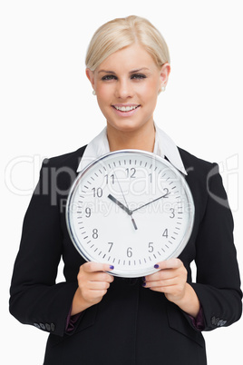 Serious blonde in suit holding a clock