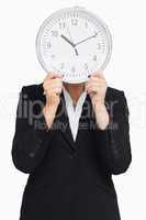 Businesswoman in suit holding a clock