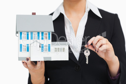 Smiling businesswoman holding a model house