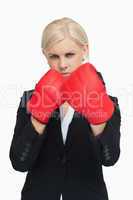 Serious businesswoman wearing red boxing gloves