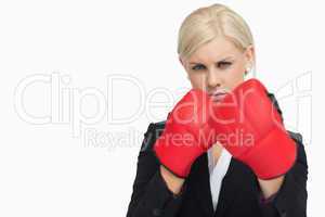 Serious blonde in suit wearing red gloves