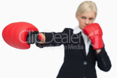 Blonde businesswoman with red gloves boxing