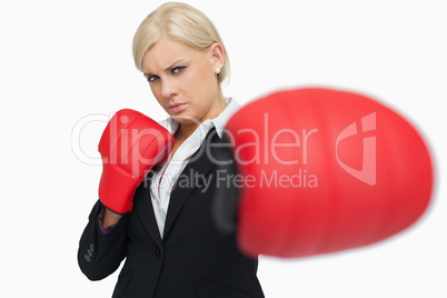 Serious businesswoman with red gloves fighting