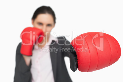 Serious brunette wearing red gloves punching