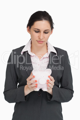 Brunette businesswoman holding a piggy-bank