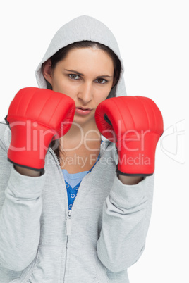 Brunette in sweatshirt wearing boxing gloves