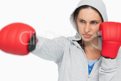 Combative brunette in sweatshirt boxing