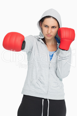 Brunette in sweatshirt boxing with red gloves