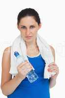 Brunette woman in sportswear with a towel and a bottle