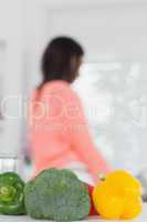 Vegetables with woman cooking in background