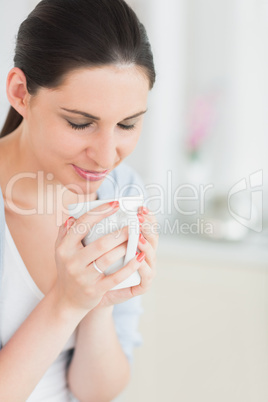 Woman with closed eyes holding a mug