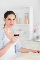 Woman reading and holding red wine glass