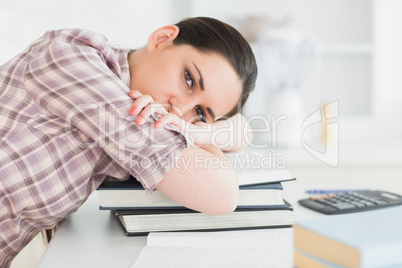 Woman leaning her head on books