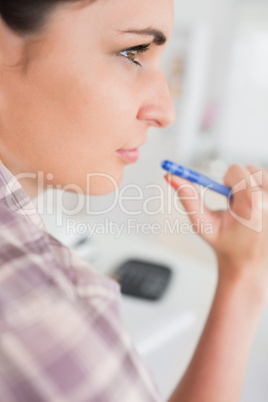 Thoughtful woman holding a pen