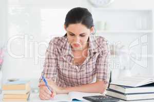 Front view of a woman writing on a notebook