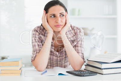 Woman holding her head on her hands while looking away