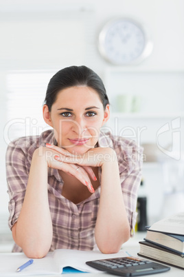 Woman looking at camera while leaning her chin on her hand