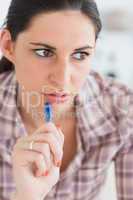 Close up of a woman thinking while holding a pen