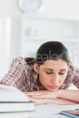 Woman with closed eyes leaning on a table