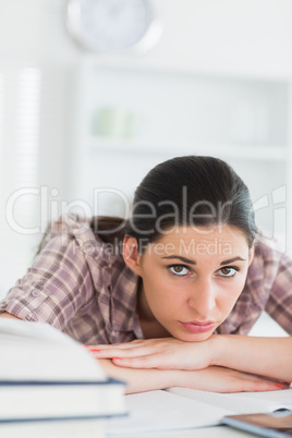 Serious woman leaning her chin on her hands on the table