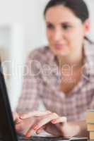 Woman typing on keyboard of laptop