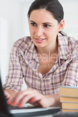 Woman typing on a keyboard while looking at a screen