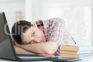 Tired woman leaning on laptop