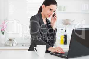 Woman calling while using a laptop