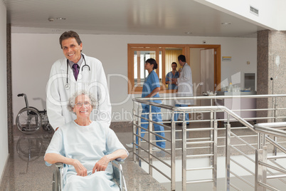 Laughing doctor pushing a wheelchair