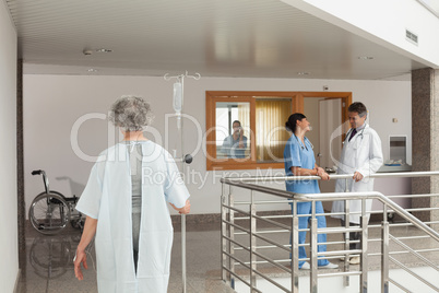 Woman walking through a hospital holding a drip