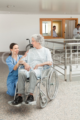 Nurse looking after old women sitting in wheelchair