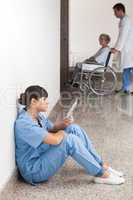 Nurse reading sitting on floor