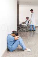 Nurse sitting on the ground with head in hands