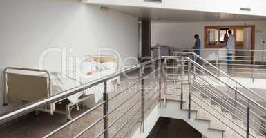 Patient lying in bed in quiet corridor