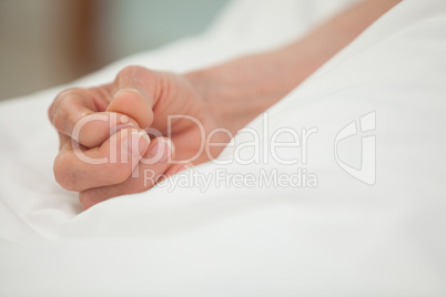 Hand in white bed cover