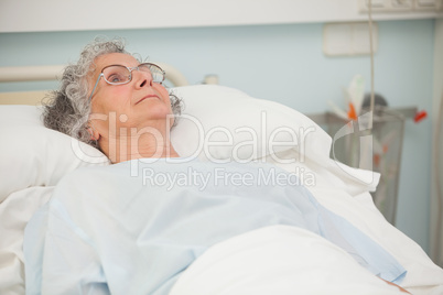 Old woman lying in hospital bed